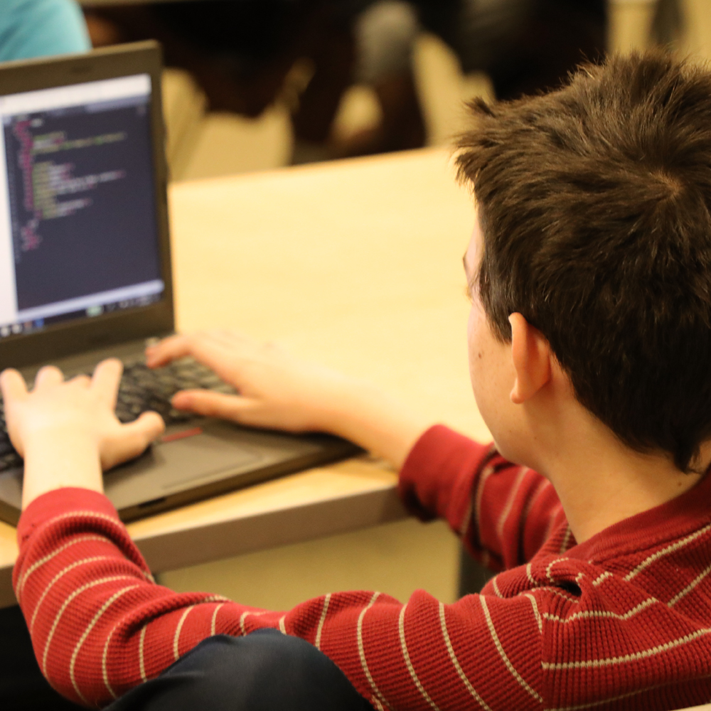 Boy coding on laptop